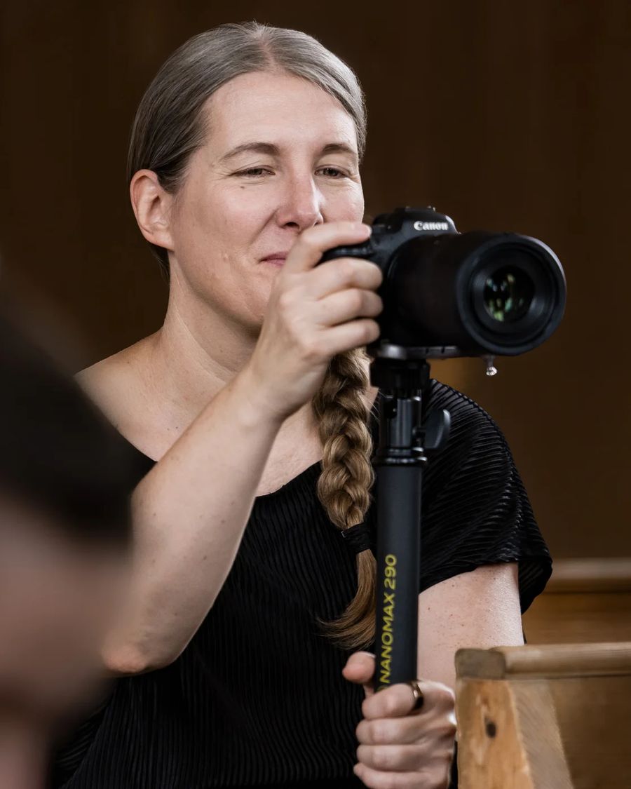 Stefanie Blochwitz mit Kamera vor dunklem Hintergrund